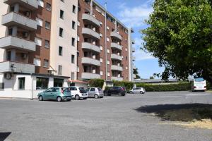 un estacionamiento con autos estacionados frente a un edificio en Hotel Palace 2000, en Pomezia