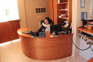 a woman sitting at a desk with a computer at Peninsula de los Coihues in Villa Pehuenia