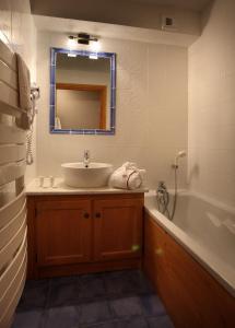 a bathroom with a sink and a tub and a mirror at Chalet des Neiges Plein Sud in Val Thorens