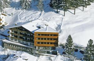um hotel na neve com neve no telhado em Hotel Mignon em Solda