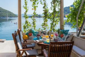 a table and chairs on a patio with a view of the water at Nono Frano in Prožura