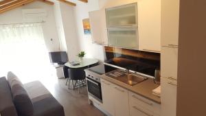 een keuken met een wastafel en een fornuis top oven bij Apartments Klelija in Zadar