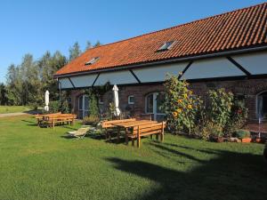 a group of picnic tables in front of a building at Gdzie diabeł mówi dobranoc in Pisz