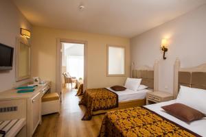 a hotel room with two beds and a television at Adalya Resort & Spa Adults Only - Ultra All Inclusive in Side +43 photos