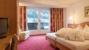 a hotel room with a bed and a large window at Haus Battisti in Sankt Anton am Arlberg