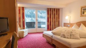 una camera d'albergo con un letto e una grande finestra di Haus Battisti a Sankt Anton am Arlberg
