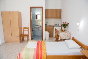 a bedroom with a bed and a kitchen with a table at Haraki View in Haraki