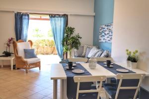un soggiorno con tavolo e sedie di Blu Marea a Macari