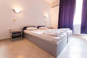 A bed or beds in a room at Plovdiv Hotel