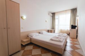 A bed or beds in a room at Plovdiv Hotel