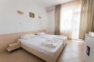 A bed or beds in a room at Plovdiv Hotel