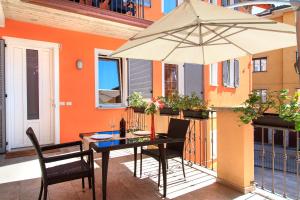 stół z parasolem na balkonie w obiekcie Apartments La Lombarda Centro Storico Stresa w mieście Stresa