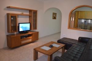 een woonkamer met een bank en een televisie bij The April Maisonette in Marsaskala