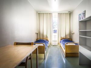 a small room with two beds and a table at Eurohostel in Helsinki