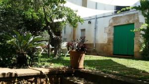 un bâtiment avec une porte verte dans une cour dans l'établissement Mas Pericay, à Pals