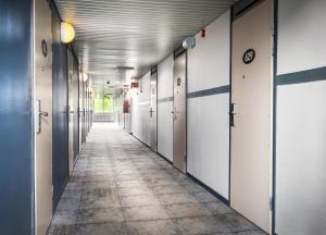 an empty hallway in an office building with white doors at Eurohostel in Helsinki