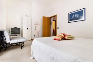1 dormitorio con 1 cama, 1 silla y TV en Sofia's House en Palermo