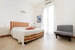 1 dormitorio blanco con 1 cama y 1 silla en Sofia's House en Palermo