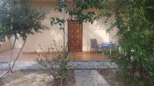 Casa con puerta de madera, mesa y sillas en Stelios Rooms, en Palaiochóra