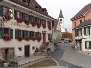 un bâtiment avec des fleurs sur le côté d'une rue dans l'établissement Gasthaus zur Sonne, à Aesch