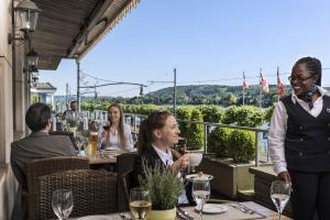 eine Gruppe von Menschen, die an einem Tisch in einem Restaurant sitzen in der Unterkunft Maritim Hotel Königswinter in Königswinter