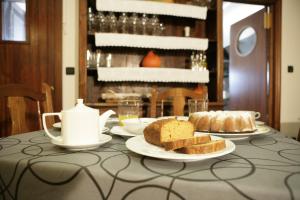 una mesa con platos de pan y un hervidor de agua. en Casa Rural Maialde, en Elgeta