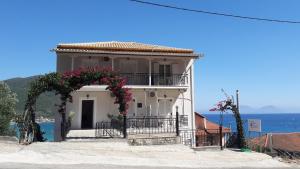 a white house with an arch and flowers on it at Sea Sound in Vasiliki
