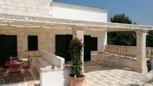 een patio met een bank en een pergola bij Masseria Conca D'Oro in Ostuni