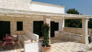 a patio with a couch and a pergola at Masseria Conca D'Oro in Ostuni