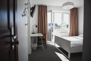 een slaapkamer met een bed, een bureau en een raam bij SAKÀ Vacation House in Druskininkai