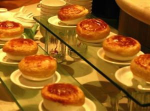 a glass case with donuts on plates on a table at Palm Beach Resort & Spa in Sanya