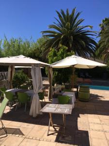 un patio con tavoli e ombrelloni accanto alla piscina di Ons Stee Bed and Breakfast a Wellington