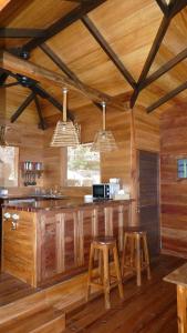 a kitchen with wooden walls and a bar with stools at Lakaz An Bwa in La Digue