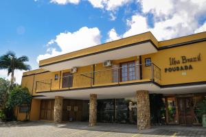 um edifício amarelo com uma varanda em cima em Pousada Ilha Brazil em Ilhabela