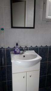 W łazience znajduje się biała umywalka i lustro. w obiekcie Apartment Amalija w Primošten