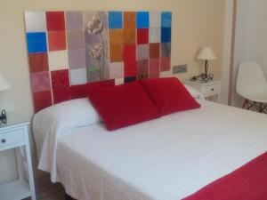 1 dormitorio con cama blanca y almohadas rojas en New La Granada, en Granada