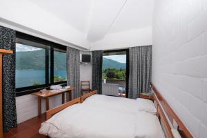 a bedroom with a bed and large windows at Hotel Campagna in Cannobio