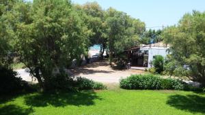 vistas a un patio con árboles y una casa en Rooms Leonidas, en Kissamos