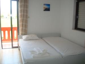 a white bed in a room with a window at Rooms Leonidas in Kissamos