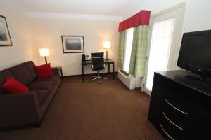 a living room with a couch and a desk and a television at Black Bear Inn & Suites in Gatlinburg