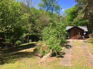 una cabaña en el bosque con un camino que conduce a ella en Cosy chalet with private sauna in Bousseviller, en Bousseviller