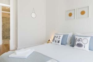 a white bedroom with a white bed with pillows at TravelingToLisbon 314 - Restauradores in Lisbon