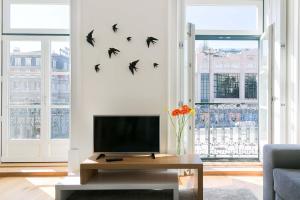 a living room with a tv and birds on the wall at TravelingToLisbon 314 - Restauradores in Lisbon