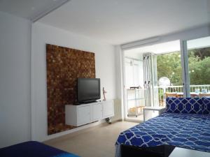 um quarto com uma cama e uma televisão na parede em Tramuntana em Platja  d'Aro