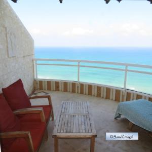 - un balcon avec un canapé et une table donnant sur l'océan dans l'établissement Nitza Seaview Apartments, à Netanya