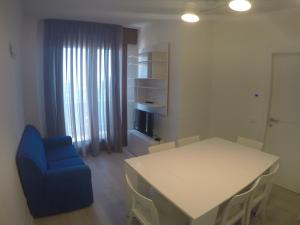 カオルレにあるCenter New Deluxe Apartaments Con Balcone Vista Mareのリビングルーム(白いテーブル、青い椅子付)