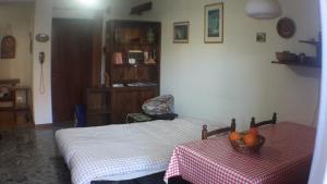 Un dormitorio con una cama y una mesa con un bol de fruta en Bilocale a Piazza Brembana, en Piazza Brembana