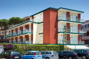 Hotel Viola في جيتا: مبنى فيه سيارات تقف امامه
