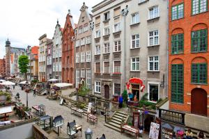 une rue urbaine avec des bâtiments, des tables et des bancs dans l'établissement The Heart of Old Town Apartments, à Gdańsk