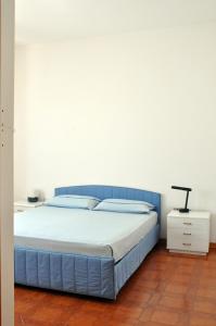 リド・マリーニにあるDue Passi Dalla Spiaggiaのベッドルーム1室(青いヘッドボード付)